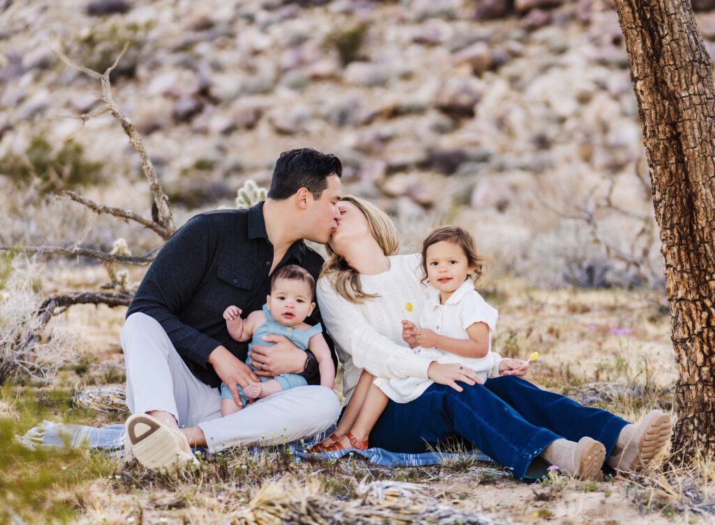 family of four sitting on rocks in the Las Vegas desert for family portraits.