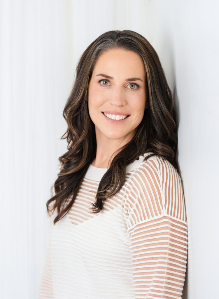 Branding session with a woman in a white shirt leaning against a white wall in Culver City.