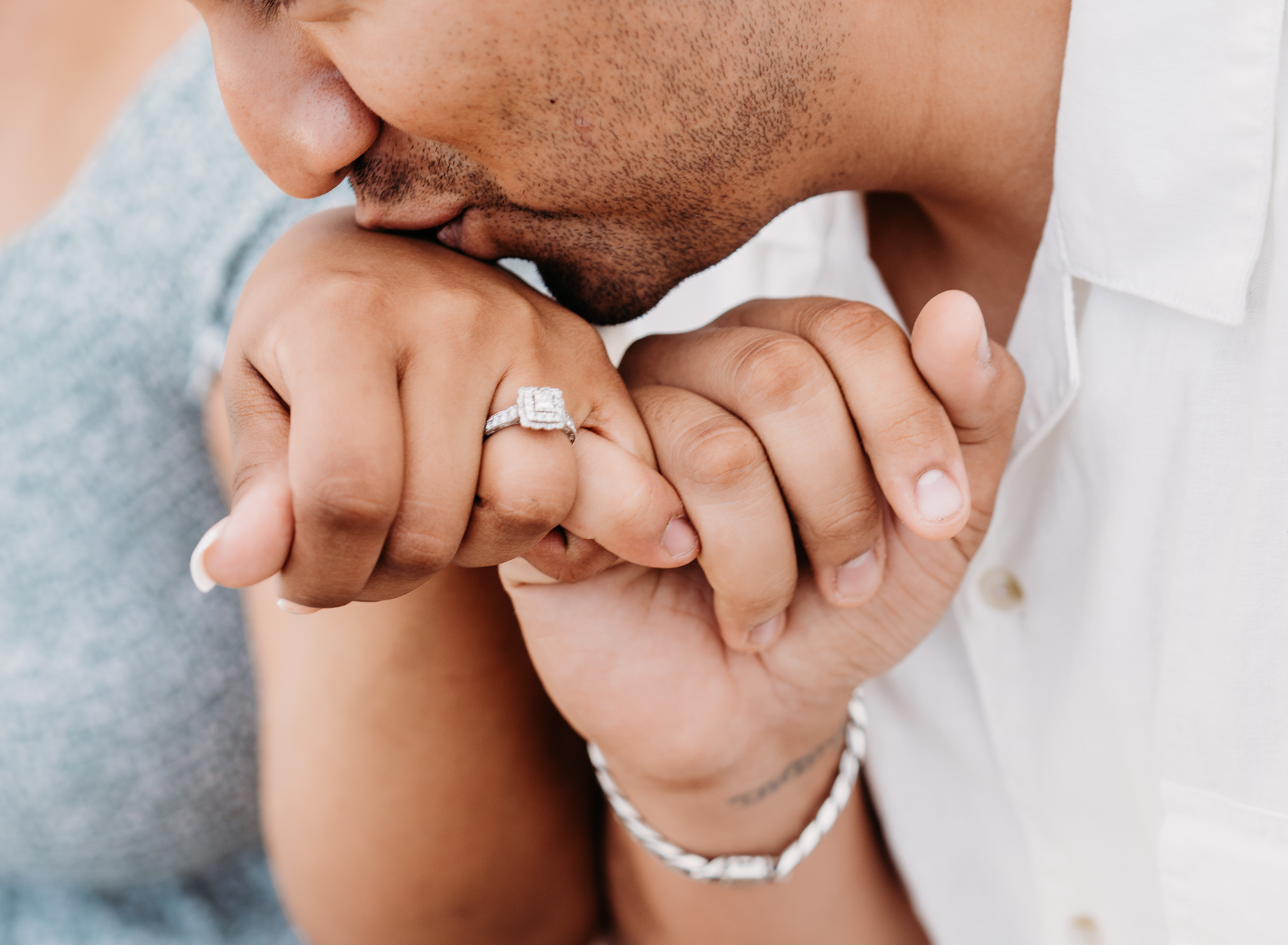 Los Angeles Engagement Photographer, Emily Winnie captures a young man kissing the hand of his bride with her engagement ring in the forefront of the camera.