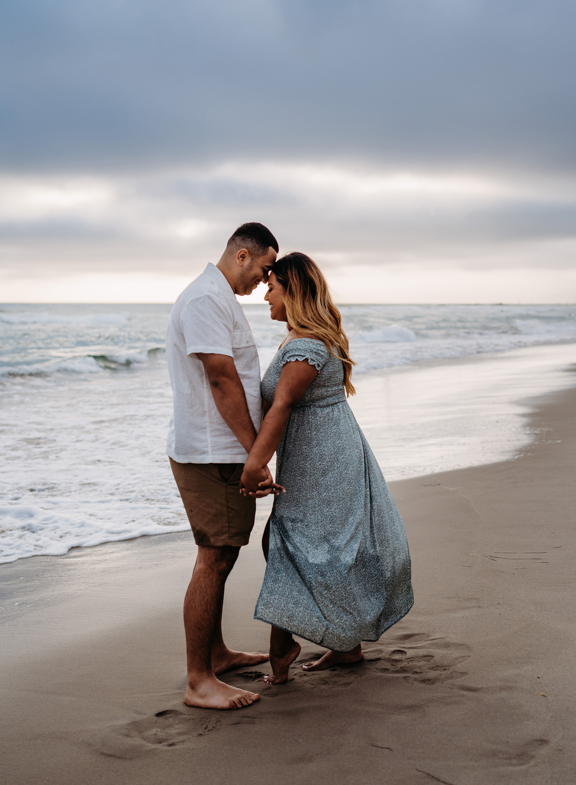 A middle-aged couple at an engagement photo location at the beach with Emily Winnie Photography.