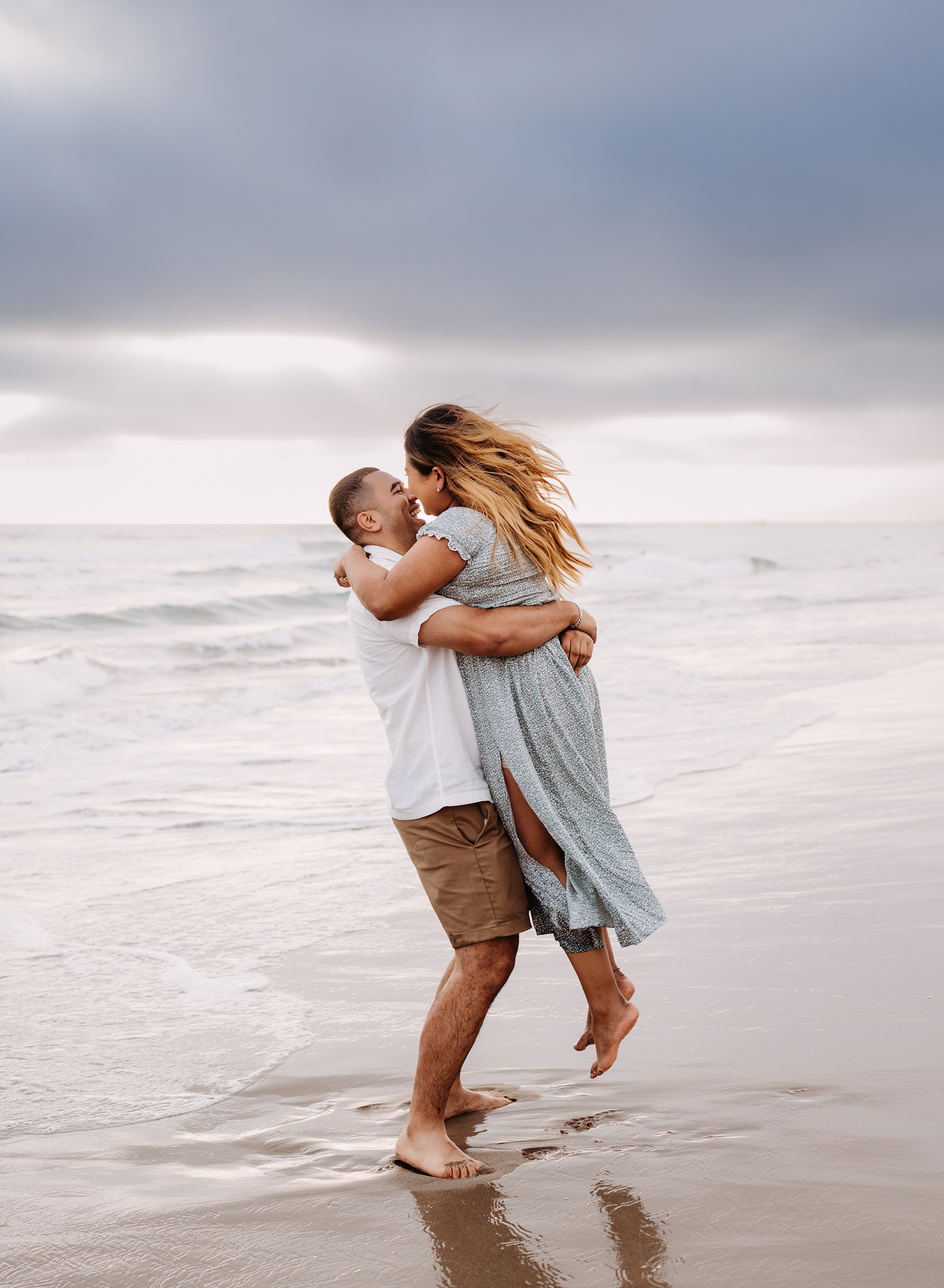A middle-aged couple at an engagement photo location at the beach with Emily Winnie Photography.