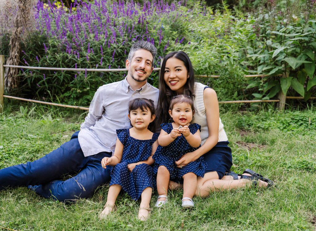 Family of 6 sitting on the grass with purple spring flowers with Culver City Family Photographer, Emily Winnie.