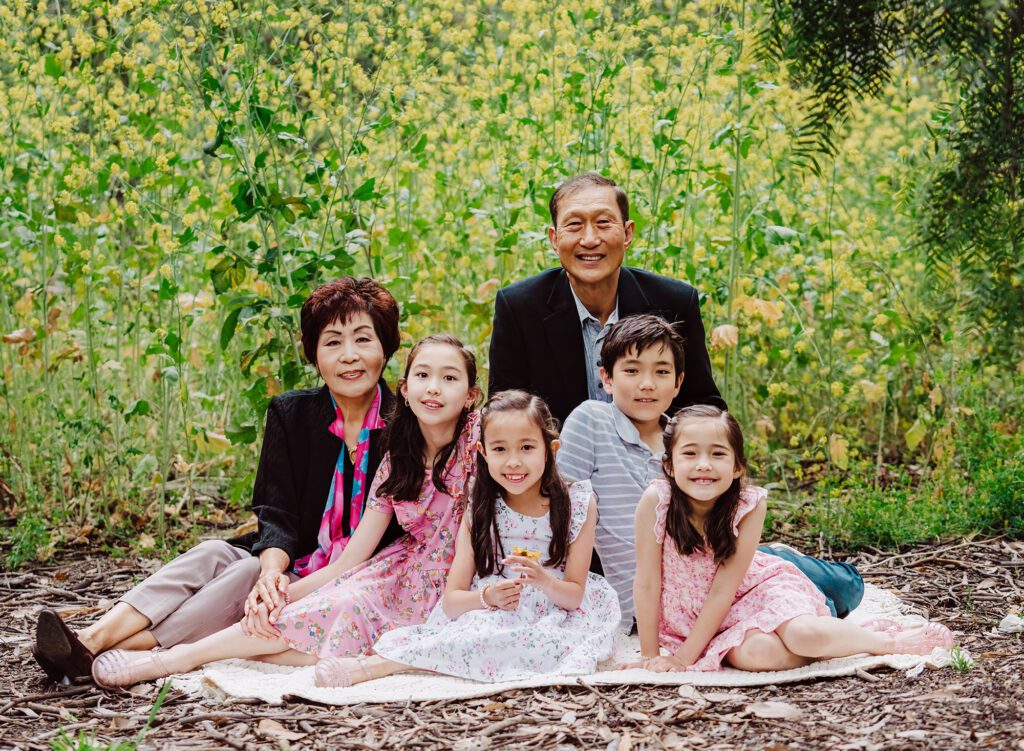 Family of 6 sitting on a blanket with yellow spring flowers with Culver City Family Photographer, Emily Winnie.